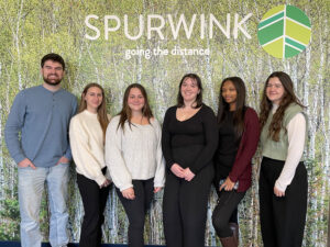 Group of six interns in front of wall