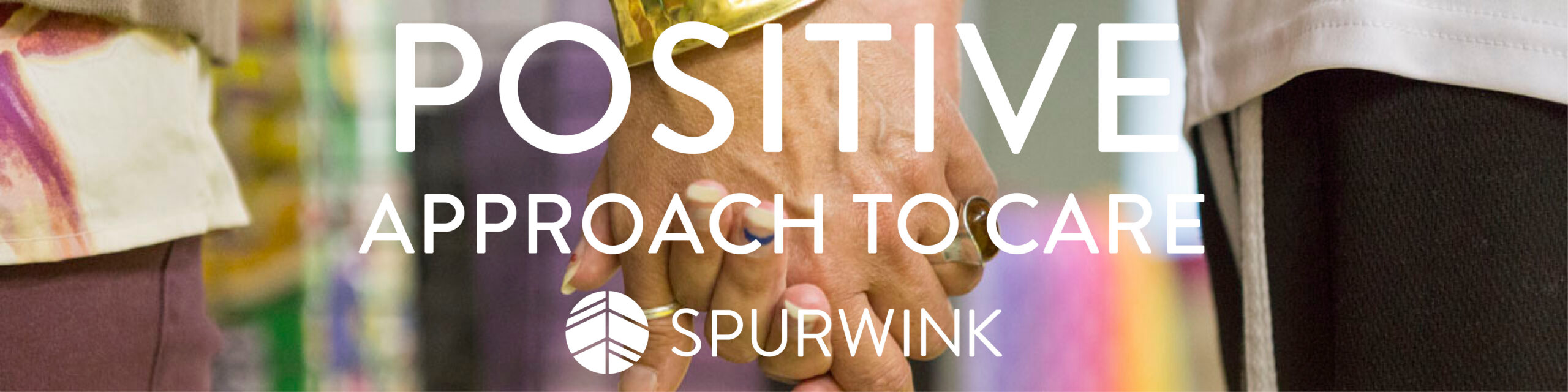 Hands holding with text saying "Positive Approach to Care"