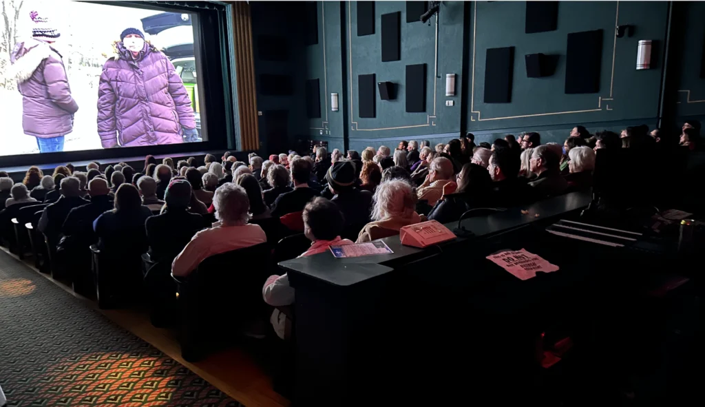 Audience watches film on large screen