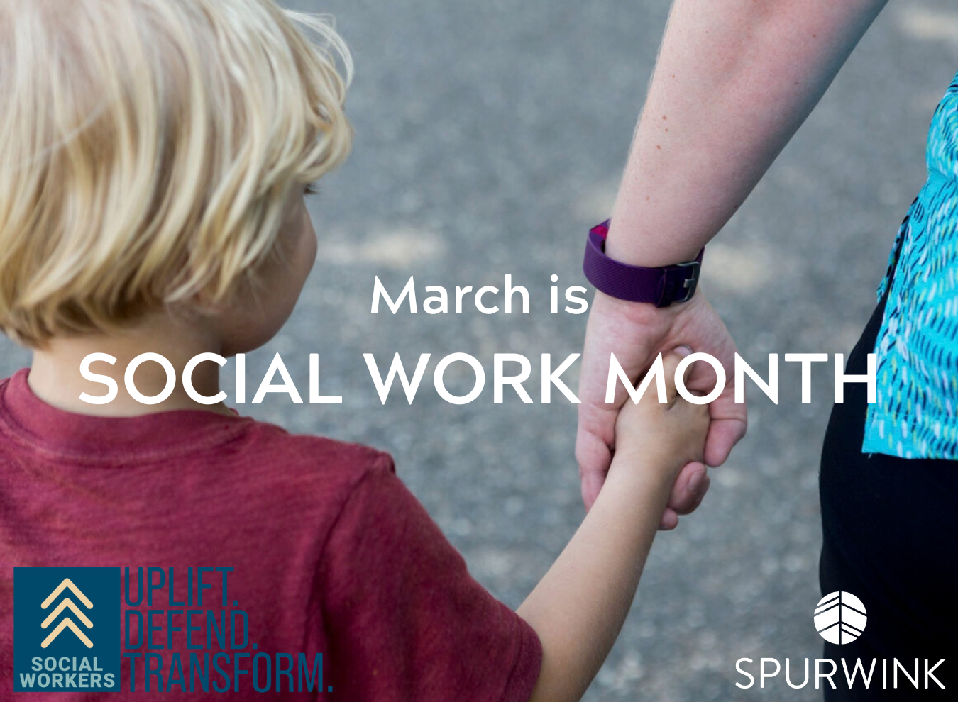 A child holds an adult's hand as they walk.