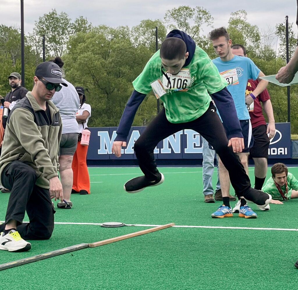 A student jumping at the special olympics.